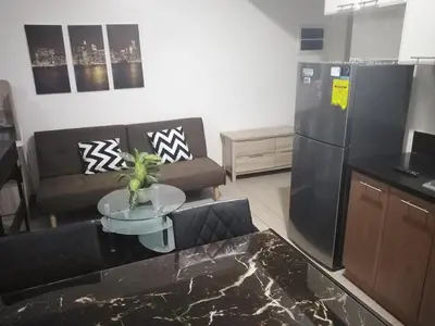 a living room with a black refrigerator and a table at Venice Mall Area Mckinley Hills Taguig in Manila
