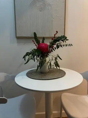a white table with a vase of flowers on it at zuvyph in Manila