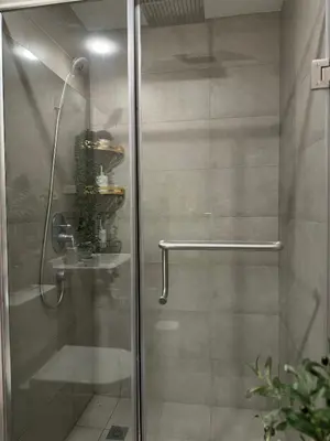 a shower with a glass door with a plant in it at zuvyph in Manila