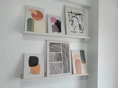 a wall with three shelves with art on them at Erro Place Wi-Fi 200mbps & Netflix in Manila