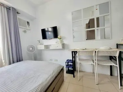 a bedroom with a bed and a desk and a tv at Erro Place Wi-Fi 200mbps & Netflix in Manila