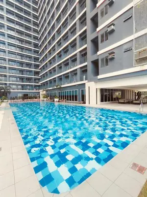 a large swimming pool in front of a building at Red Residences Modern Apartment with City View in Makati in Manila