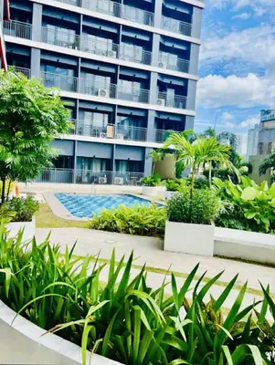 a large apartment building with a swimming pool and plants at Red Residences Modern Apartment with City View in Makati in Manila