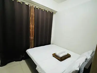 a small room with a bed with a black curtain at Shore 1br shortwalk mall of asia in Manila