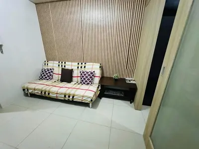 a room with a couch with pillows on it at Shore 1br shortwalk mall of asia in Manila