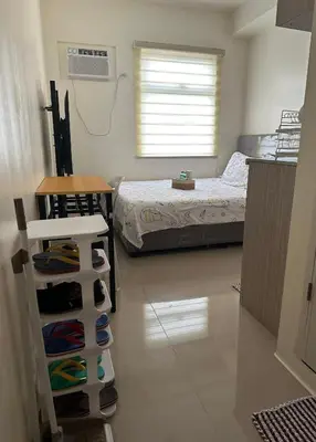 a bedroom with a bed and a table with a table at Staycation in Sucat Road in Manila