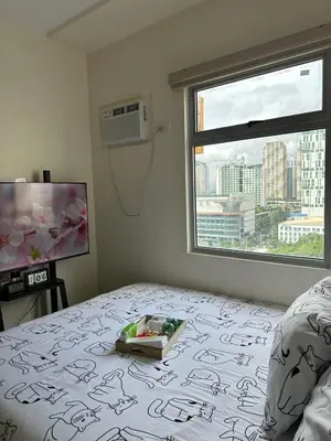 a bedroom with a bed and a window at Staycation in Sucat Road in Manila