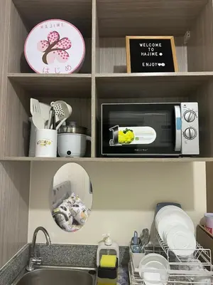 a kitchen with a sink and a microwave at Staycation in Sucat Road in Manila