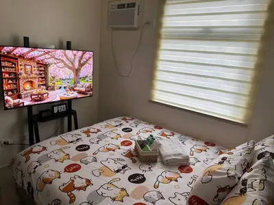 a bedroom with a bed with a dog comforter and a window at Staycation in Sucat Road in Manila