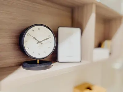 a clock sitting on a shelf next to a cell phone at The Luxe Haven at BGC in Sampong