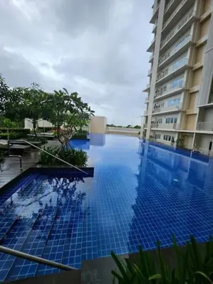 a large blue swimming pool next to a building at The Luxe Haven at BGC in Sampong