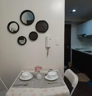 a table with plates and mirrors on the wall at Cozy Pad-50th in Manila