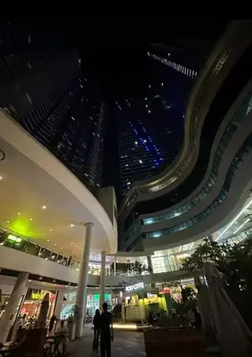 a large building with people walking in front of it at night at Cozy Pad-50th in Manila