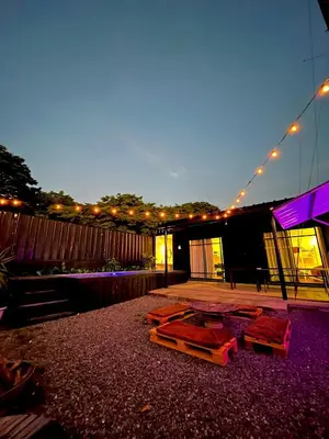 a patio with tables and lights on a building at Boxify Cabins