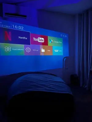a bedroom with a large screen above a bed at Boxify Cabins