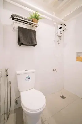 a white bathroom with a toilet and a shower at Canopyproperties in Manila