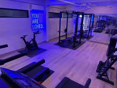 a gym with exercise equipment and a sign that says you are love at Canopyproperties in Manila