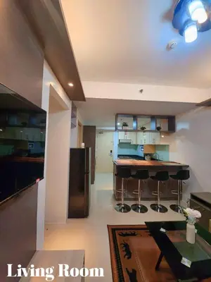 a kitchen with a living room with a refrigerator and a table at Staycation 2 Bedroom at Sea Residences Pasay across Mall of Asia near NAIA Airport in Manila