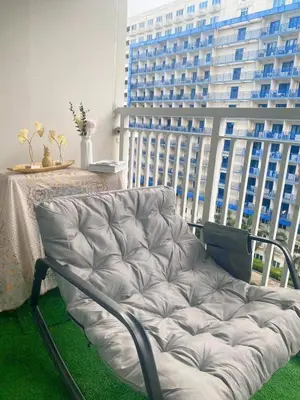 a couch in a room with a large building at Staycation 2 Bedroom at Sea Residences Pasay across Mall of Asia near NAIA Airport in Manila
