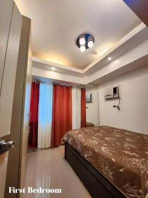 a bedroom with a bed and a window with red curtains at Staycation 2 Bedroom at Sea Residences Pasay across Mall of Asia near NAIA Airport in Manila