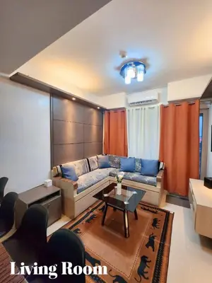 a living room with a couch and a table at Staycation 2 Bedroom at Sea Residences Pasay across Mall of Asia near NAIA Airport in Manila