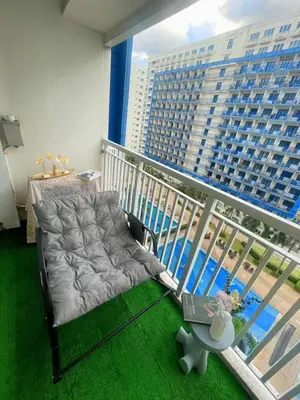 a chair on a balcony with a view of a building at Staycation 2 Bedroom at Sea Residences Pasay across Mall of Asia near NAIA Airport in Manila