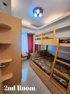 a bedroom with two bunk beds and a door at Staycation 2 Bedroom at Sea Residences Pasay across Mall of Asia near NAIA Airport in Manila