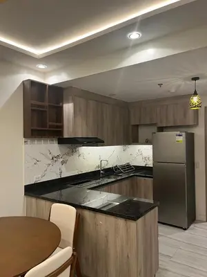 a kitchen with a stainless steel refrigerator and a table at Cozy Modern Apartment with Luxury Amenities in Manila