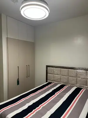 a bedroom with a large bed with a striped rug at Cozy Modern Apartment with Luxury Amenities in Manila