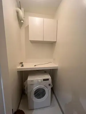 a laundry room with a washing machine under a counter at Cozy Modern Apartment with Luxury Amenities in Manila