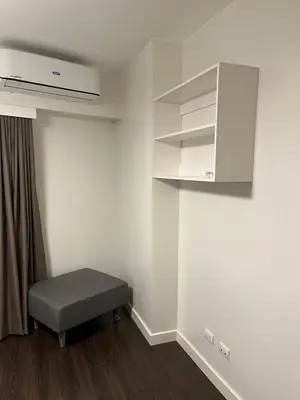 an empty room with a bench and a cabinet at Cozy Modern Apartment with Luxury Amenities in Manila