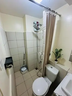 a small bathroom with a toilet and a shower at 17th Casa Horizon in Manila