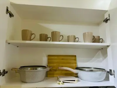 two shelves with pots and pans on them in a kitchen at 17th Casa Horizon in Manila