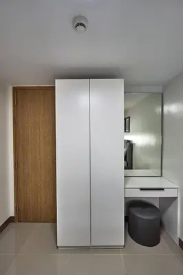 a white cabinet in a room with a desk at Modern Loft-Style Condo - Perfect for Families or Couples in Manila