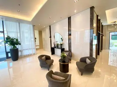 a lobby with chairs and a table and a mirror at Modern Loft-Style Condo - Perfect for Families or Couples in Manila