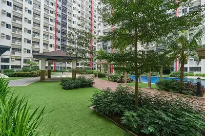 a park in a building with a tree and a building at Modern Loft-Style Condo - Perfect for Families or Couples in Manila