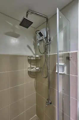 a shower with a shower head in a bathroom at Modern Loft-Style Condo - Perfect for Families or Couples in Manila