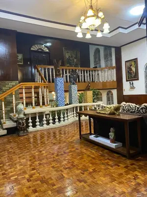 a living room with a wooden floor and stairs at Big Beautiful House in Pasig in Manila