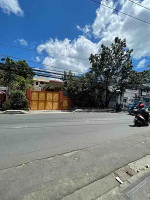 an empty street with a motorcycle parked on the side of the road at Big Beautiful House in Pasig in Manila