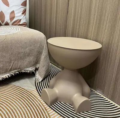 a bedroom with a bed with a white table and a bedskirtspectspectspects at Cozy Haven in Manila