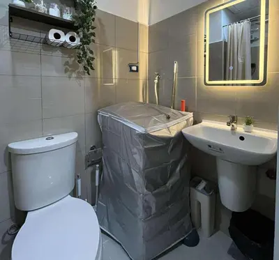 a bathroom with a white toilet and a sink at Cozy Haven in Manila