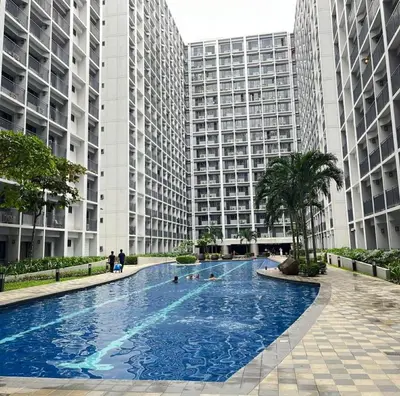 a large swimming pool in front of two tall buildings at Cozy Haven in Manila