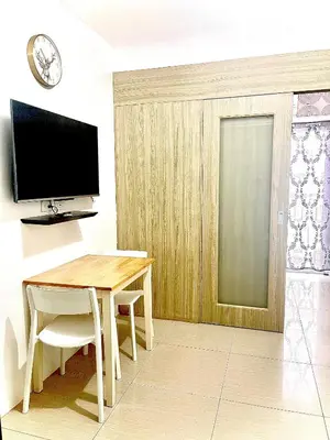 a dining room with a table and a television at 1 bedroom near MOA NAIA with parking slot included pls send valid ids of guests after booking in Manila