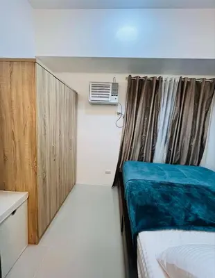 a small room with a bed and a window at Sarah's Place at Light Residences in Manila