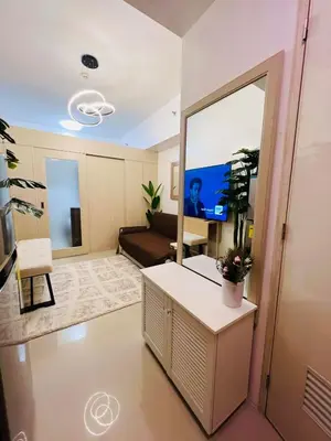 a living room with a tv and a mirror at Sarah's Place at Light Residences in Manila