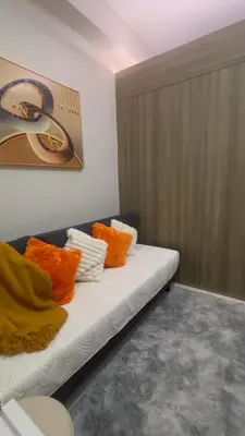 a room with a couch with orange pillows on it at CitySoul in Manila
