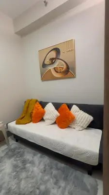 a white couch with four colorful pillows on it at CitySoul in Manila