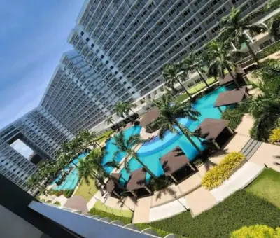 a building with a swimming pool in front of a building at Ritzy Pasay Getaway - Entire Apartment for Rent in Manila