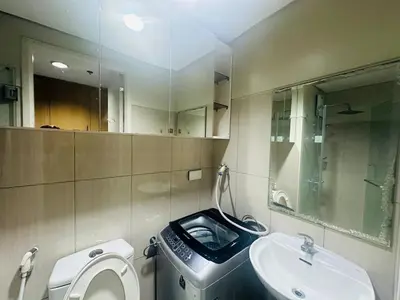 a bathroom with a toilet and a sink and a mirror at Ritzy Pasay Getaway - Entire Apartment for Rent in Manila