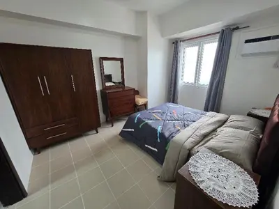 a bedroom with a bed and a dresser and a mirror at 2 BR Penthouse with Sunset View in Manila